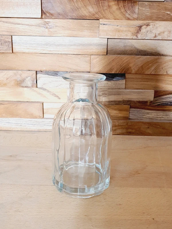 Petit vase soliflore cylindrique en verre transparent massif avec une base large et stable, design épuré des années 1970.