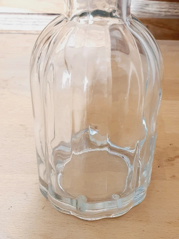 Petit vase soliflore cylindrique en verre transparent massif avec une base large et stable, design épuré des années 1970.