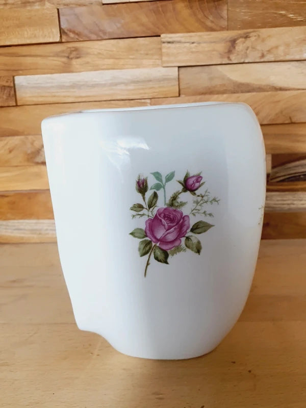 Pot mural arrondi en porcelaine blanche brillante orné de motifs de roses roses et rouges, avec trous de fixation au dos, style vintage romantique.