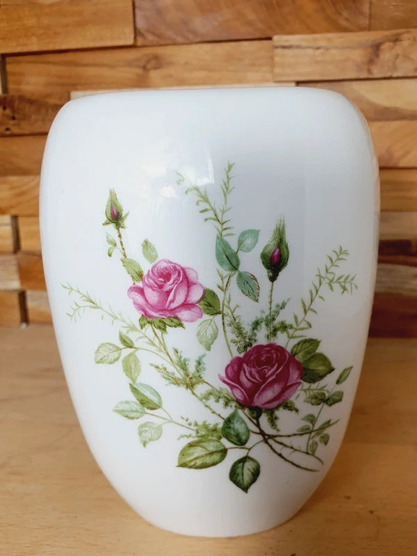 Pot mural arrondi en porcelaine blanche brillante orné de motifs de roses roses et rouges, avec trous de fixation au dos, style vintage romantique.