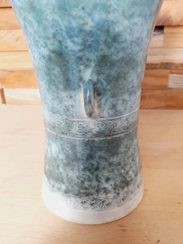 Poterie artisanale en grès avec décor de nœuds celtiques gravés, émail vert et blanc moucheté, deux petites anses sur les côtés, style vintage britannique.