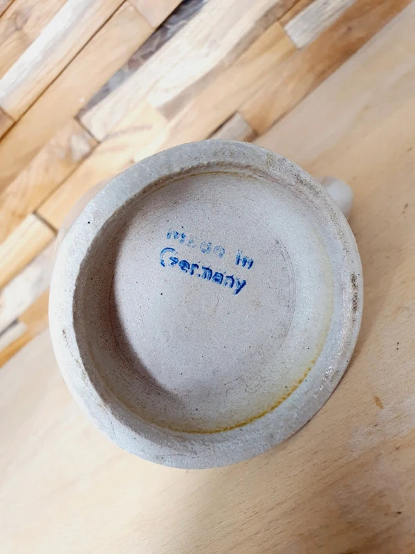 Petite choppe à bière en grès gris et bleu cobalt avec logo Kronenbourg en relief, fabriquée en Allemagne, style traditionnel rustique.