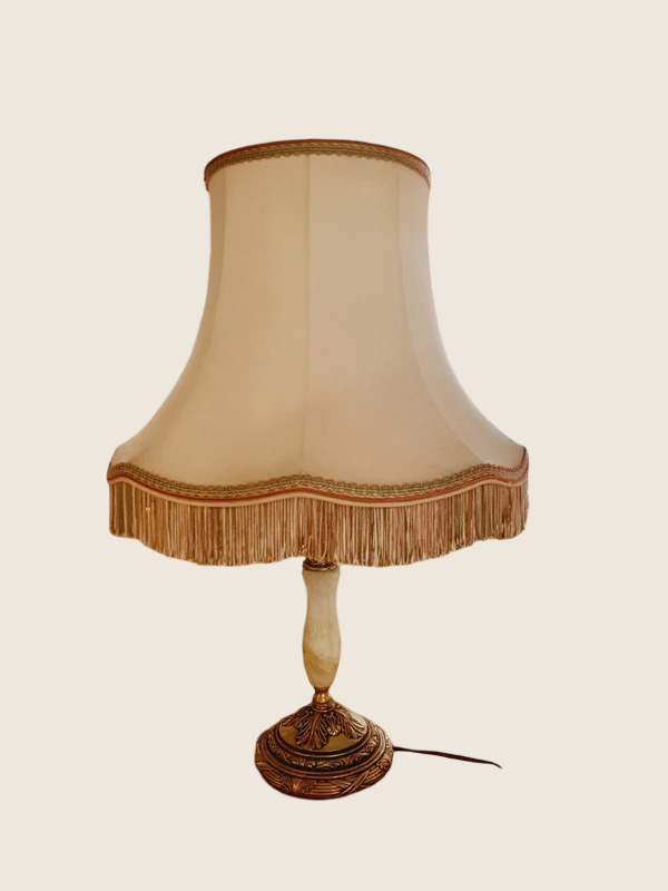 Grande lampe à poser rétro avec pied sculpté en albâtre blanc veiné et monture en laiton doré, surmontée d'un large abat-jour crème à franges.