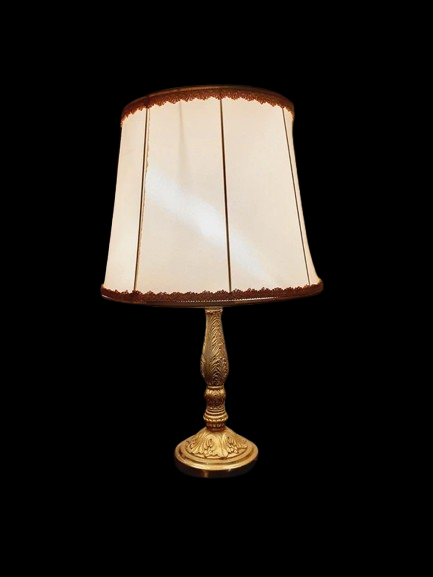 Lampe de table de style Regency & Art Français années 50-60. Hauteur 55,5 cm. Elle possède un pied en laiton sculpté combinant une base ornée. Son grand abat-jour en tissu de couleur crème est bordé de galons décoratifs. 