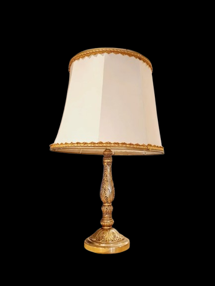 Lampe de table de style Regency & Art Français années 50-60. Hauteur 55,5 cm. Elle possède un pied en laiton sculpté combinant une base ornée. Son grand abat-jour en tissu de couleur crème est bordé de galons décoratifs. 