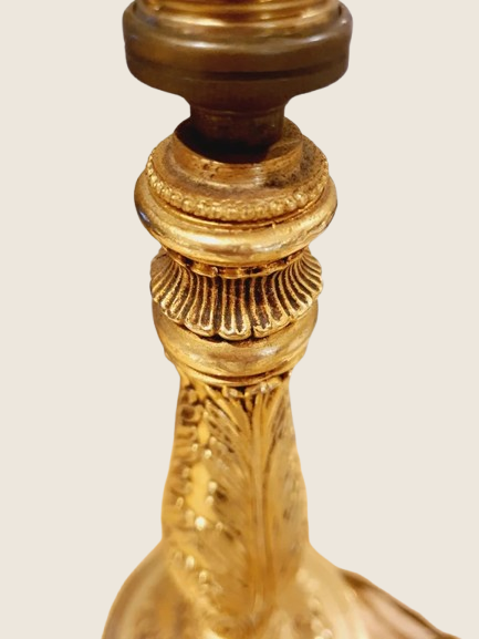 Lampe de table de style Regency & Art Français années 50-60. Hauteur 55,5 cm. Elle possède un pied en laiton sculpté combinant une base ornée. Son grand abat-jour en tissu de couleur crème est bordé de galons décoratifs. 