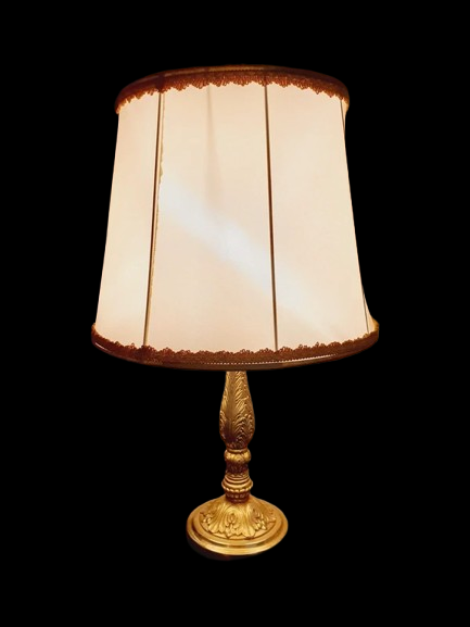 Lampe de table de style Regency & Art Français années 50-60. Lampe en laiton haussmannien vintage. Elle possède un pied en laiton sculpté combinant une base ornée. Son grand abat-jour en tissu de couleur crème est bordé de galons décoratifs. 