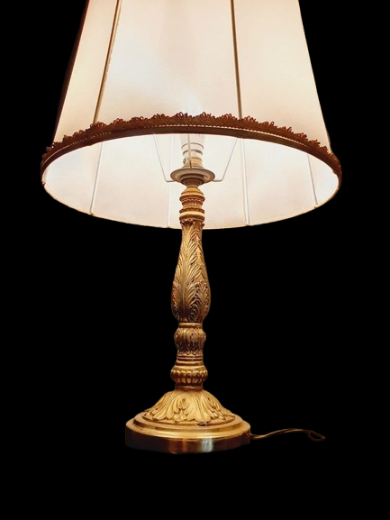 Lampe de table de style Regency & Art Français années 50-60. Lampe en laiton haussmannien vintage. Elle possède un pied en laiton sculpté combinant une base ornée. Son grand abat-jour en tissu de couleur crème est bordé de galons décoratifs. 