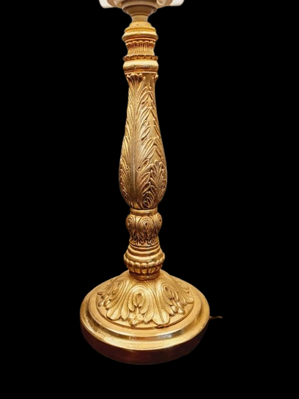 Lampe de table de style Regency & Art Français années 50-60. Hauteur 55,5 cm. Elle possède un pied en laiton sculpté combinant une base ornée. Son grand abat-jour en tissu de couleur crème est bordé de galons décoratifs. 