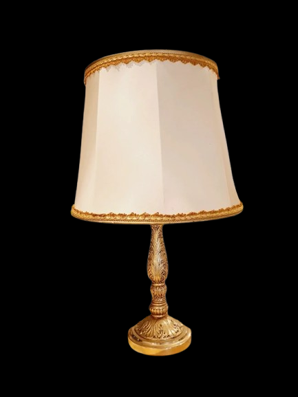 Lampe de table de style Regency & Art Français années 50-60. Lampe en laiton haussmannien vintage. Elle possède un pied en laiton sculpté combinant une base ornée. Son grand abat-jour en tissu de couleur crème est bordé de galons décoratifs. 