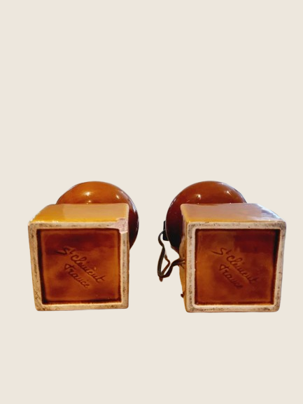 Paire de pieds de lampe céramique de couleur marron terre, style poterie Vallauris ancienne des années 70. Présentés sur un fond clair, montrant leur texture brute et leur forme cubique à la base.