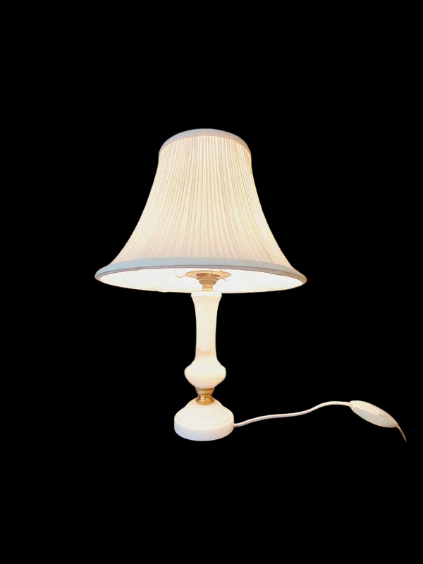 Petite lampe de chevet vintage avec un pied cylindrique en albâtre blanc veiné et un abat-jour plissé en tissu blanc, diffusant une lumière tamisée