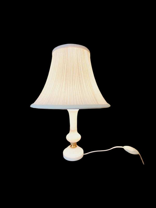 Petite lampe de chevet vintage avec un pied cylindrique en albâtre blanc veiné et un abat-jour plissé en tissu blanc, diffusant une lumière tamisée