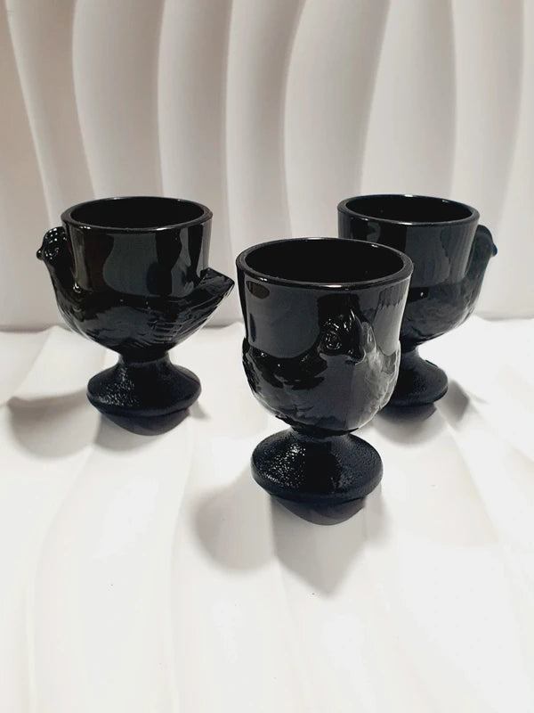 Lot de trois coquetiers poules vintage en verre opale noir de la marque Luminarc France, design rétro des années 1970 posés sur fond blanc.