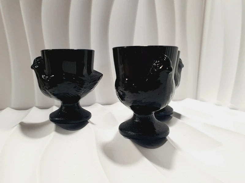 Lot de trois coquetiers poules vintage en verre opale noir de la marque Luminarc France, design rétro des années 1970 posés sur fond blanc.