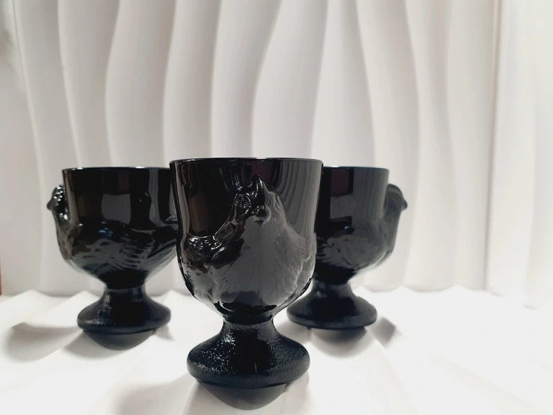 Lot de trois coquetiers poules vintage en verre opale noir de la marque Luminarc France, design rétro des années 1970 posés sur fond blanc.