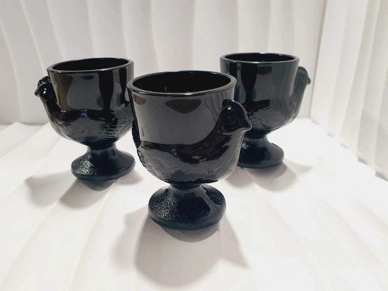 Lot de trois coquetiers poules vintage en verre opale noir de la marque Luminarc France, design rétro des années 1970 posés sur fond blanc.