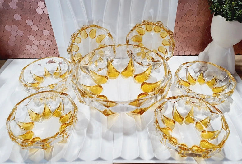 Service à dessert vintage en verre moulé épais jaune topaze ambré, comprenant un saladier central et six coupelles individuelles assorties, disposés sur une table pour un dressage rétro élégant.