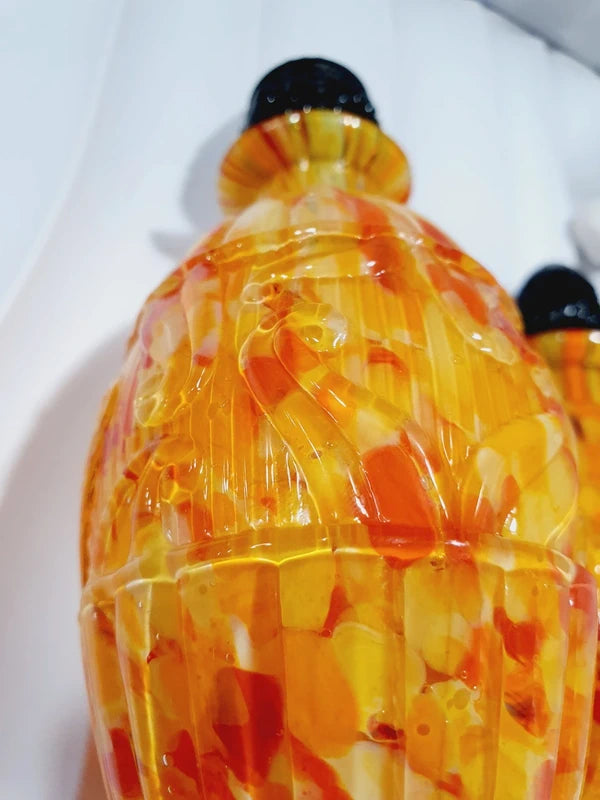 Duo de flacons de toilette Art Déco de 1930 en verre pressé moulé jaspé orange rouge jaune avec bouchons noirs facettés.