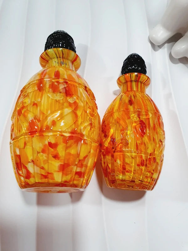 Duo de flacons de toilette Art Déco de 1930 en verre pressé moulé jaspé orange rouge jaune avec bouchons noirs facettés.