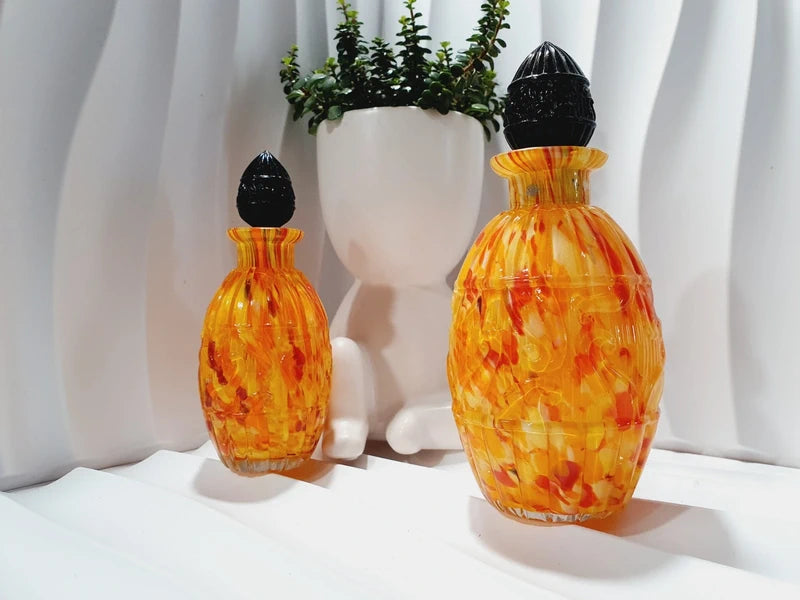 Duo de flacons de toilette Art Déco de 1930 en verre pressé moulé jaspé orange rouge jaune avec bouchons noirs facettés.