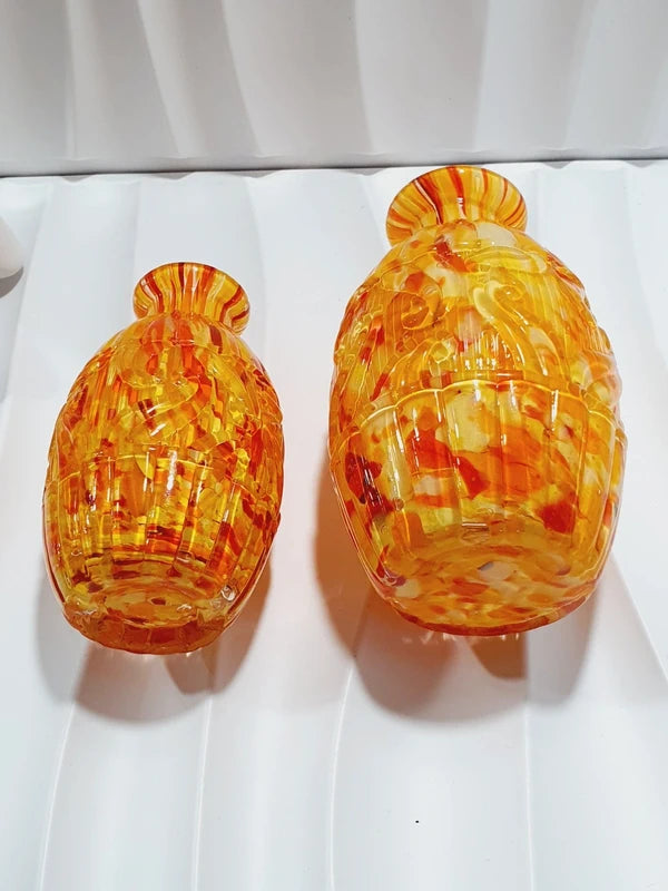 Duo de flacons de toilette Art Déco de 1930 en verre pressé moulé jaspé orange rouge jaune avec bouchons noirs facettés.
