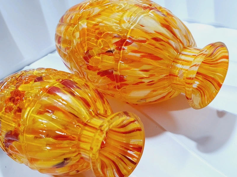 Duo de flacons de toilette Art Déco de 1930 en verre pressé moulé jaspé orange rouge jaune avec bouchons noirs facettés.