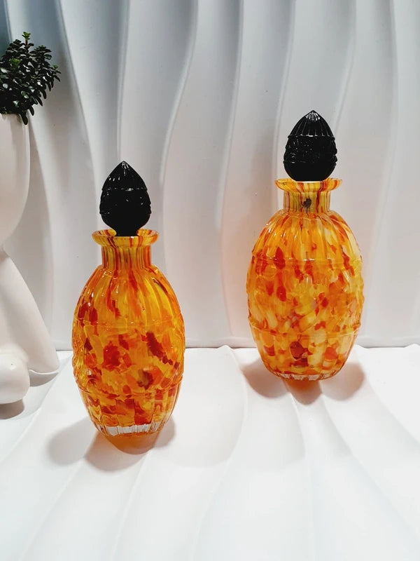 Duo de flacons de toilette Art Déco de 1930 en verre pressé moulé jaspé orange rouge jaune avec bouchons noirs facettés.