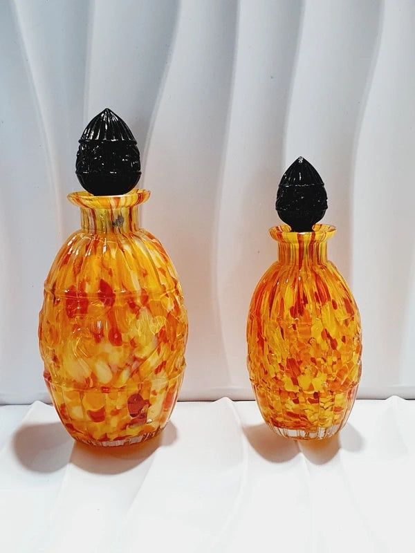 Duo de flacons de toilette Art Déco de 1930 en verre pressé moulé jaspé orange rouge jaune avec bouchons noirs facettés.