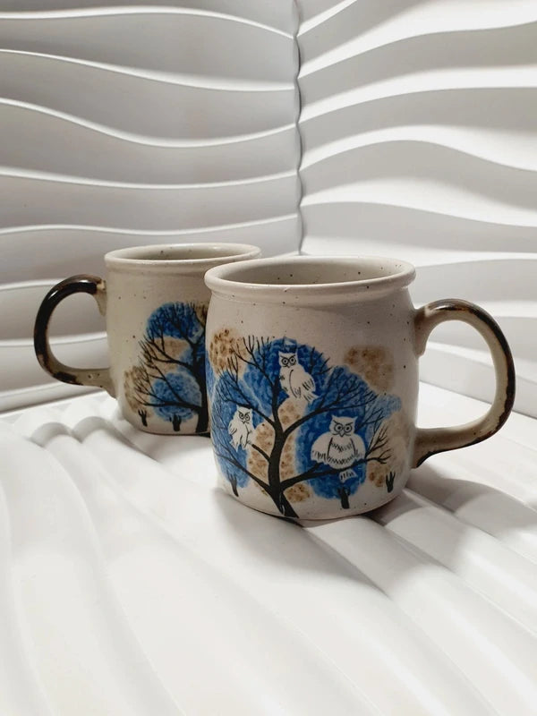 Deux mugs vintage en grès de la marque japonaise Otagiri avec un décor en relief de chouettes blanches dans les arbres sur fond bleu et beige.