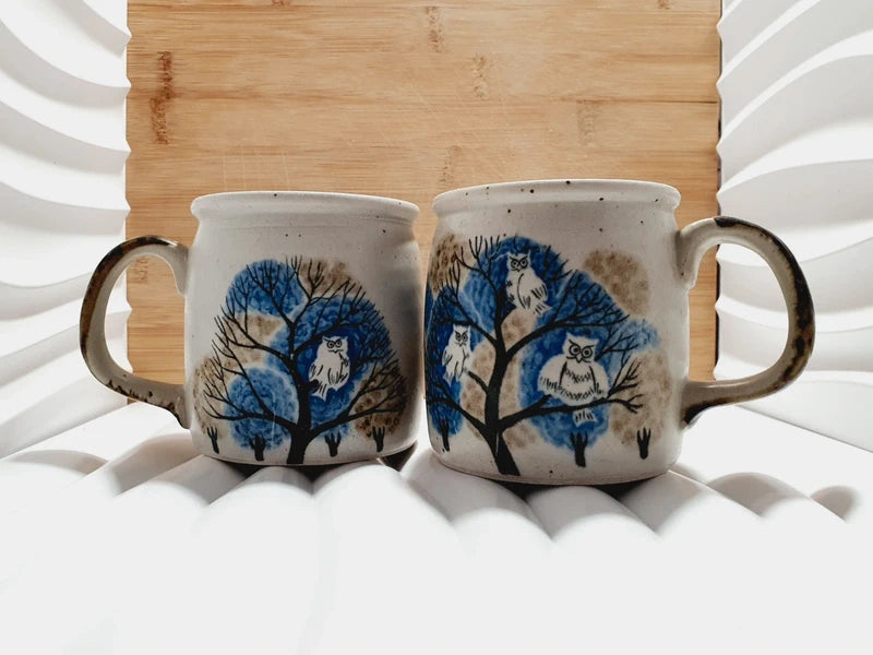 Deux mugs vintage en grès de la marque japonaise Otagiri avec un décor en relief de chouettes blanches dans les arbres sur fond bleu et beige
