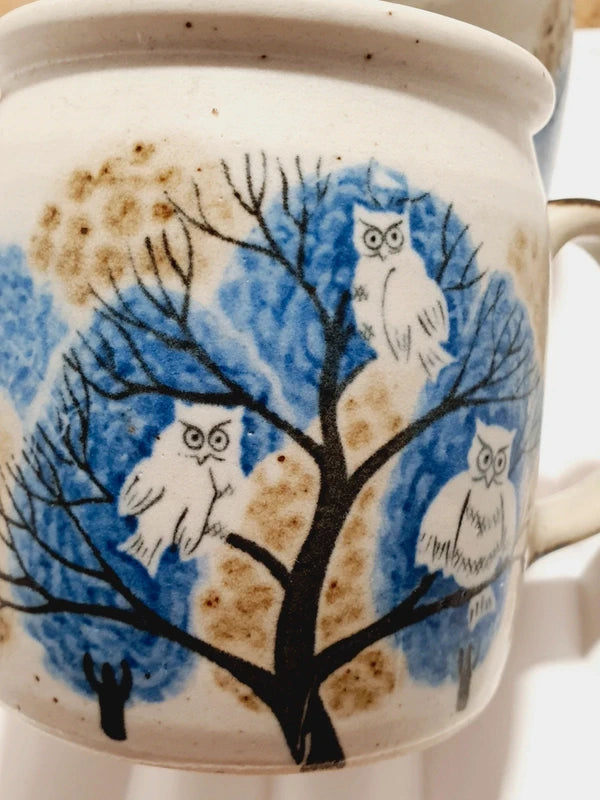 Deux mugs vintage en grès de la marque japonaise Otagiri avec un décor en relief de chouettes blanches dans les arbres sur fond bleu et beige.