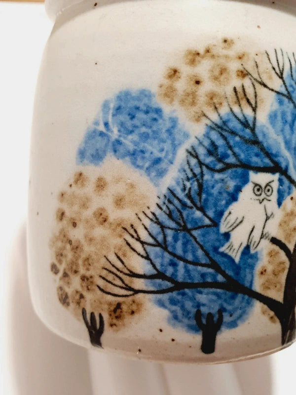 Deux mugs vintage en grès de la marque japonaise Otagiri avec un décor en relief de chouettes blanches dans les arbres sur fond bleu et beige.