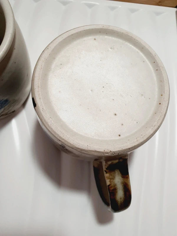 Deux mugs vintage en grès de la marque japonaise Otagiri avec un décor en relief de chouettes blanches dans les arbres sur fond bleu et beige.