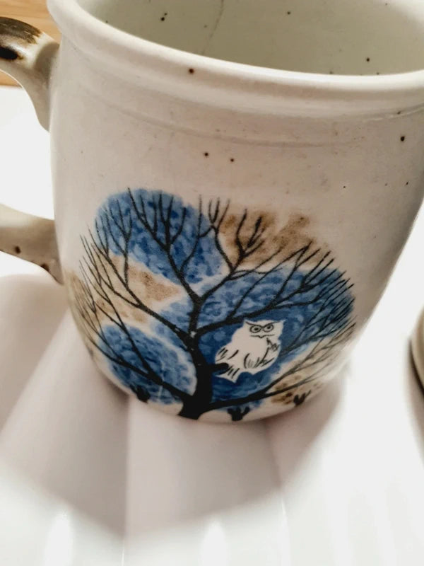 Deux mugs vintage en grès de la marque japonaise Otagiri avec un décor en relief de chouettes blanches dans les arbres sur fond bleu et beige.