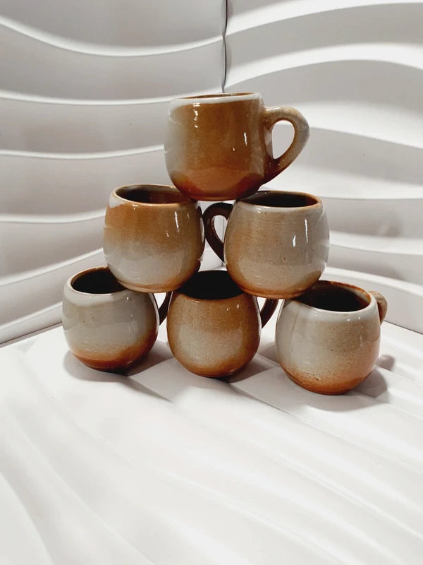 Lot de six petits godets ou mini chopes de service à digestif ou calvados avec anse en grès véritable bicolore marron ocre et crème verni brillant, style vaisselle rustique et art populaire des années 1970.