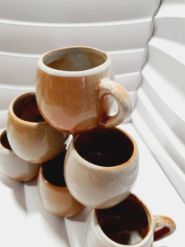 Lot de six petits godets ou mini chopes de service à digestif ou calvados avec anse en grès véritable bicolore marron ocre et crème verni brillant, style vaisselle rustique et art populaire des années 1970.