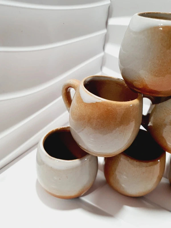 Lot de six petits godets ou mini chopes de service à digestif ou calvados avec anse en grès véritable bicolore marron ocre et crème verni brillant, style vaisselle rustique et art populaire des années 1970.