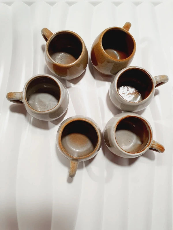 Lot de six petits godets ou mini chopes de service à digestif ou calvados avec anse en grès véritable bicolore marron ocre et crème verni brillant, style vaisselle rustique et art populaire des années 1970.