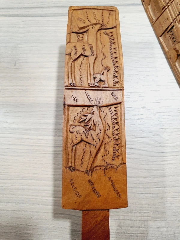Ensemble de couverts à salade vintage en bois véritable sculpté à la main des années 1970 composé d'une grande fourchette trident et d'une cuillère louche, ornées de motifs de cerfs, biches et faons en relief sur le manche avec encoche repose-plat au dos, montrant un léger éclat de cuisson ou d'usage sur le rebord supérieur du buvant.