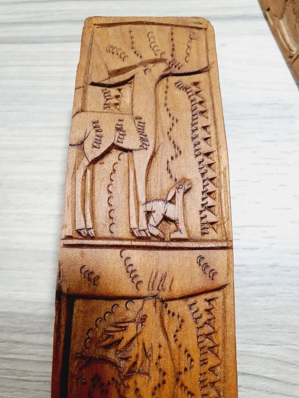 Ensemble de couverts à salade vintage en bois véritable sculpté à la main des années 1970 composé d'une grande fourchette trident et d'une cuillère louche, ornées de motifs de cerfs, biches et faons en relief sur le manche avec encoche repose-plat au dos, montrant un léger éclat de cuisson ou d'usage sur le rebord supérieur du buvant.