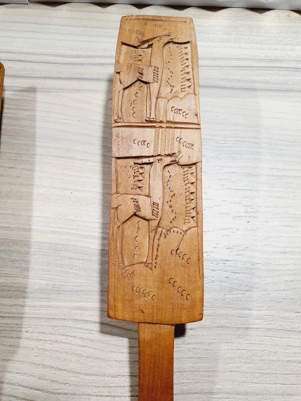 Ensemble de couverts à salade vintage en bois véritable sculpté à la main des années 1970 composé d'une grande fourchette trident et d'une cuillère louche, ornées de motifs de cerfs, biches et faons en relief sur le manche avec encoche repose-plat au dos, montrant un léger éclat de cuisson ou d'usage sur le rebord supérieur du buvant.