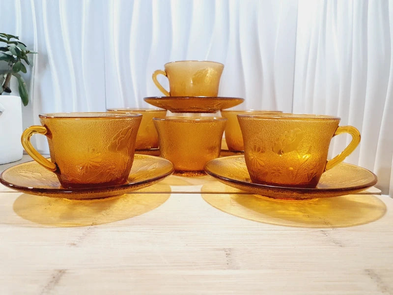 Service de tasses à café et sous-tasses assorties en verre trempé ambré transparent avec motifs de fleurs en relief et extérieur givré, marque Arcoroc France époque années 1970.