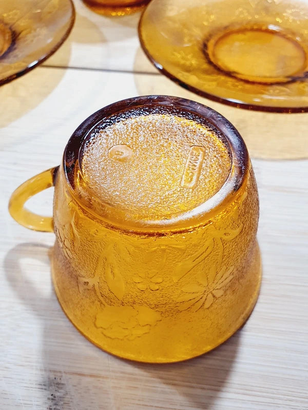 Service de tasses à café et sous-tasses assorties en verre trempé ambré transparent avec motifs de fleurs en relief et extérieur givré, marque Arcoroc France époque années 1970.