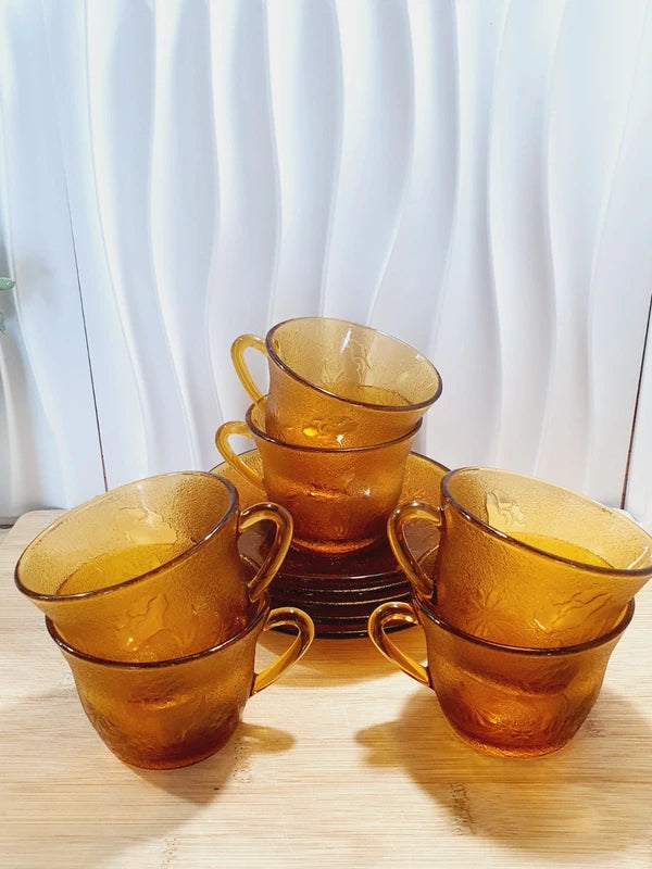 Service de tasses à café et sous-tasses assorties en verre trempé ambré transparent avec motifs de fleurs en relief et extérieur givré, marque Arcoroc France époque années 1970.