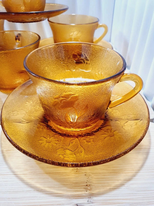 Service de tasses à café et sous-tasses assorties en verre trempé ambré transparent avec motifs de fleurs en relief et extérieur givré, marque Arcoroc France époque années 1970.