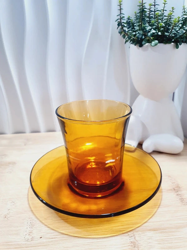 Tasse haute de forme gobelet sans anse et sa sous-tasse assortie en verre trempé de couleur ambrée transparente, de la marque Duralex France époque années 1970.