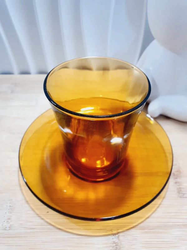 Tasse haute de forme gobelet sans anse et sa sous-tasse assortie en verre trempé de couleur ambrée transparente, de la marque Duralex France époque années 1970.