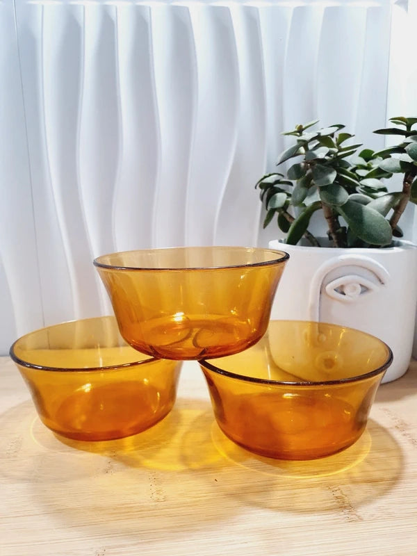 Lot de trois petits bols coupelles en verre trempé de couleur ambrée transparente, vaisselle de table de style pop épuré d'époque des années 1970 pour la décoration.