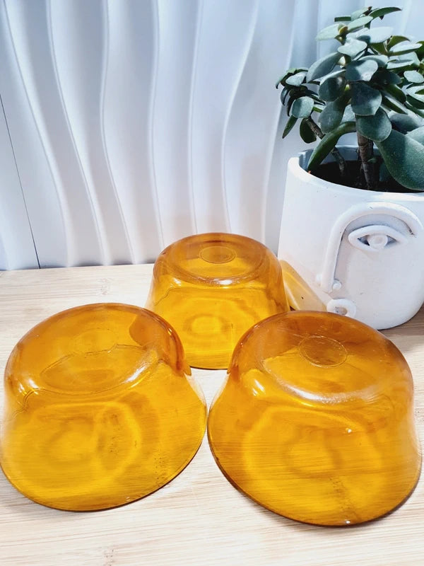 Lot de trois petits bols coupelles en verre trempé de couleur ambrée transparente, vaisselle de table de style pop épuré d'époque des années 1970 pour la décoration.